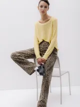 Sweater de punto color amarillo, con cuello redondo y mangas largas. Corte regular y textura suave.