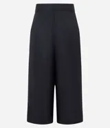 Pantalón pantacourt de sastrería con diseño amplio, cintura alta y pliegues frontales. Presenta piernas anchas, largo midi y cierre frontal discreto.