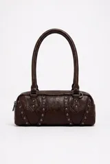Cartera tipo baguette color granate, de diseño alargado, con detalles de tachas metálicas plateadas y doble asa corta para el hombro.