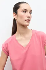 Remera verde oliva con cuello en V, mangas cortas y detalle de vainillas en las costuras de las mangas y el ruedo.