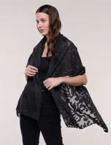 Pashmina rectangular de tejido liviano y vaporoso, color negro, con diseño de motivos botánicos abstractos que combinan transparencias y relieve.