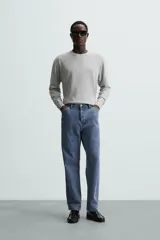 Jersey color crudo de tejido de punto, con cuello redondo y mangas largas. Corte amplio y terminaciones en rib.