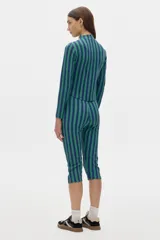 Calza capri negra de tiro alto con protección UV factor 50 y detalle de línea blanca en los laterales.