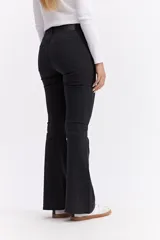 Jean de corte oxford con tiro alto, ajustado hasta la rodilla y con apertura amplia en el bajo. Confeccionado en denim negro con cierre frontal de botón y cremallera.