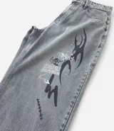 Pantalón de jeans para hombre, modelo super baggy, color celeste desgastado, con estampa de grafiti en negro en ambas piernas. Presenta cintura con trabilla, cierre tradicional y bolsillos.