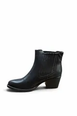 Bota tipo Chelsea color marrón, con taco cuadrado y suela negra. Presenta elástico lateral con costuras pespuntadas visibles y diseño clásico.