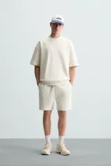 Sudadera de manga corta color marrón oscuro, con cuello redondo y bajo acabado en rib. Presenta un corte relajado y holgado (boxy fit).