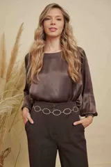 Blusa de satén color champagne con cuello a la base, mangas anchas y puños elásticos con detalle bordado.