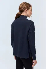 Polera tejida de punto confeccionada en lambswool color gris claro, con cuello alto y calce holgado.