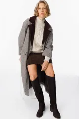 Bota alta de cuero color chocolate, con diseño de caña recta y detalle de pespuntes decorativos a lo largo de la pierna. Cuenta con un taco bajo cuadrado y cierre lateral.