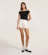 Short de mujer modelo mom de cintura alta, confeccionado en sarga de algodón. Presenta trabillas en la cintura, cierre tradicional, bolsillos y apliques de brillo.