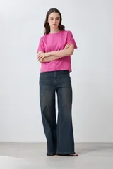 Remera fucsia de manga corta con detalle de broderie en las mangas.