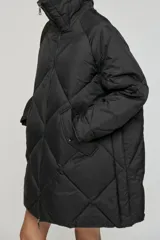 Campera puffer acolchada de corte oversize, color verde oliva, con diseño de rombos, cuello alto y cierre frontal con cremallera.