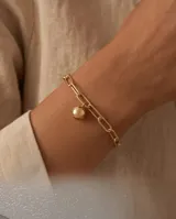 Pulsera de plata con baño de oro, compuesta por una cadena de eslabones rectangulares combinados con una cadena fina, y un dije colgante en forma de esfera lisa.