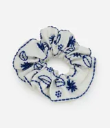 Scrunchie blanco con bordados azules de motivos marinos.