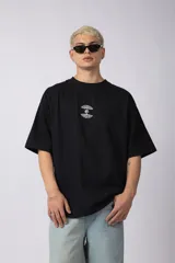 Remera de corte oversize confeccionada en algodón premium pesado, color negro. Presenta un bordado frontal minimalista con diseño de árboles unidos por sus raíces y un parche estampado en la espalda con una silueta de mano fusionada con ramas.