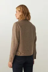 Campera de lana fina sin teñir, con cuello alto, cierre frontal completo y diseño de corte recto con pespuntes decorativos en puños, ruedo y cuello.