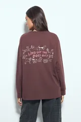 Remera de manga larga en color blanco, con corte relajado y cuello redondo. Presenta un pequeño estampado gráfico en la parte inferior frontal con la frase 'WHO WH WHO?' y un dibujo de un perro.