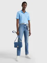 Chomba celeste de piqué de algodón con cuello ribeteado, cartera de cinco botones, logo de Tommy Hilfiger bordado en el pecho y bandera de Tommy Hilfiger bordada en la manga.