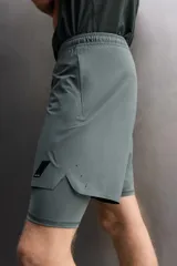 Pantalones cortos de entrenamiento 2 en 1 de Zara Athleticz, confeccionados en tejido técnico ligero y elástico. Presentan una malla interior integrada, cintura elástica con cordón ajustable, bolsillos laterales con cierre y aberturas en el bajo.