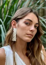 Aros colgantes con textura irregular y apliques de piedras de colores.