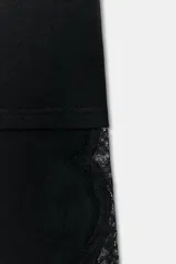 Camiseta de algodón de corte regular, color marrón oscuro o negro, con cuello redondo y manga corta. Presenta un bajo asimétrico con aplicación de encaje negro a tono.