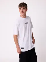 Remera de corte oversize, color blanco, con cuello redondo y logo de la marca estampado en el centro del pecho.