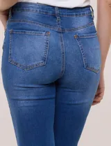 Jean elastizado tiro alto de la marca Absolutely Famous, con calce ajustado en caderas y muslos y botamanga acampanada. Presenta diseño clásico de cinco bolsillos, cierre frontal con botón y bragueta, y costuras en contraste.