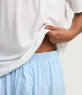 Conjunto de pijama corto para hombre, compuesto por una remera de manga corta con cuello redondo y bolsillo en el pecho, y un short con cintura elástica. Diseño a rayas finas.