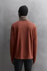 Camiseta deportiva color durazno de manga larga con orificios para los pulgares.