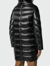 Campera de nylon color caqui, con relleno de plumas, cuello alto y cierre con broches a presión.