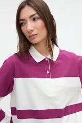 Remera polo de manga larga de algodón lavado, con diseño de rayas horizontales anchas en azul y blanco, cuello y cartera de botones en color blanco, y pequeños tajos laterales.