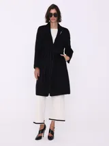 Tapado trench negro con vivo al tono, corte clásico, largo hasta la rodilla y cinturón con trabillas.