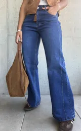 Jean de corte recto y tiro alto en color azul lavado, con costuras verticales decorativas en el frente y cierre frontal con botón metálico.