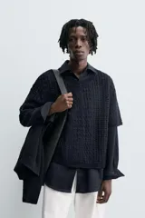 Camiseta de tejido de punto crochet con estructura abierta, color azul marino. Presenta cuello redondo y mangas cortas.