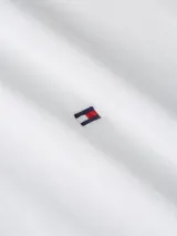 Camisa blanca de algodón regenerativo, de corte entallado, manga larga y cuello inglés. Presenta cierre con botones y logo de la marca bordado en el pecho.