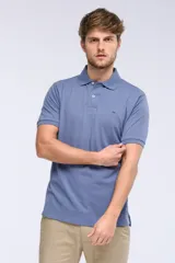 Remera polo de piqué de manga corta, color celeste, con cuello camisero, cartera con botones y pequeño logo bordado en el pecho.