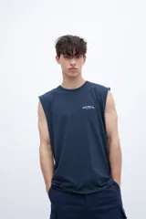 Musculosa azul marino con cuello redondo y sisas amplias. Presenta un pequeño estampado en el pecho con texto en blanco.