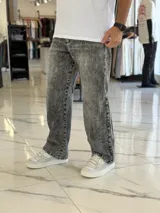 Pantalón de jean gris con lavado ácido, corte holgado de estilo oversize y diseño recto.