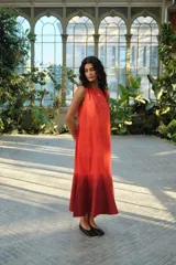 Vestido largo sin mangas, con escote redondo, corte amplio y volado en la parte inferior. Presenta un diseño bicolor con efecto degradado en tonos rojo y bordó.