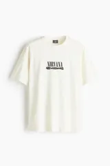 Remera de algodón color crema con cuello redondo acanalado y diseño estampado de Nirvana Nevermind en el centro del pecho.