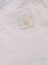 Pantalón celeste a rayas verticales blancas, de corte recto, con cintura elástica y cordón ajustable.