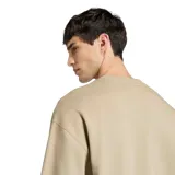 Buzo de cuello redondo Adidas, confeccionado en tejido French Terry color beige. Presenta un diseño minimalista con el logo de la marca bordado en el centro del pecho y puños acanalados.