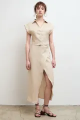 Falda midi de lino con diseño cruzado y tajo frontal.