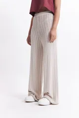 Pantalón de punto color ladrillo con diseño calado, cintura elástica y corte palazzo.