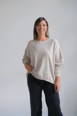 Sweater de punto color beige, de corte holgado y diseño minimalista con cuello redondo y mangas largas.