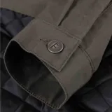 Campera verde oliva con cuello de pana negro, cierre frontal con cremallera y logo bordado en el pecho.