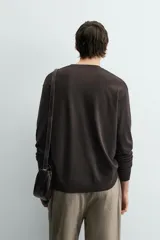 Jersey color crudo de tejido de punto, con cuello redondo y mangas largas. Corte amplio y terminaciones en rib.