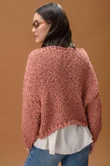 Buzo de tejido de punto grueso con textura, de corte oversize y mangas largas con caída holgada.