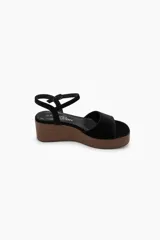 Sandalias de plataforma con cuña efecto madera y capellada de gamuza negra, con tira ancha en la parte delantera y tira ajustable alrededor del tobillo.